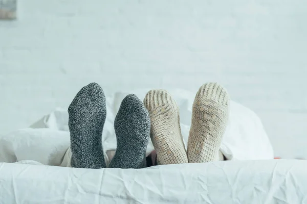 Обрезанный Снимок Пары Шерстяных Носках Лежащих Постели Дома — стоковое фото