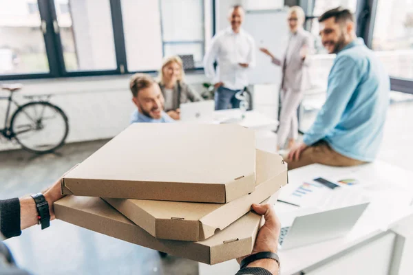 Recortado Tiro Hombre Trayendo Pizza Compañeros Felices Oficina — Foto de Stock