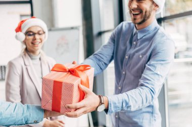 mutlu genç işadamı meslektaşım ofiste Noel hediye sunmak kadeh kırpılmış