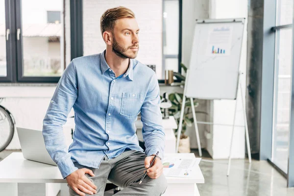 Handsome Young Businessman Sitting Table Pencil Hand Looking Away Office — Stock Photo, Image