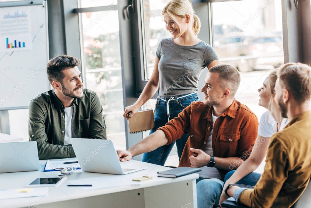 group of young entrepreneurs talking while working on startup together at office