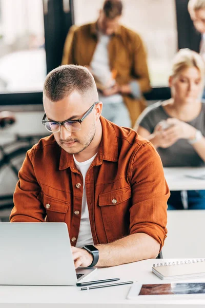 Schöner Junger Mann Arbeitet Mit Laptop Großraumbüro Mit Kollegen Hintergrund — Stockfoto