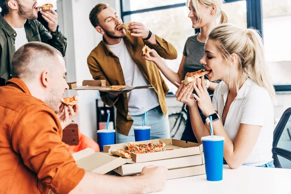 Grupo Jóvenes Empresarios Felices Comiendo Pizza Para Almorzar Juntos Mientras —  Fotos de Stock