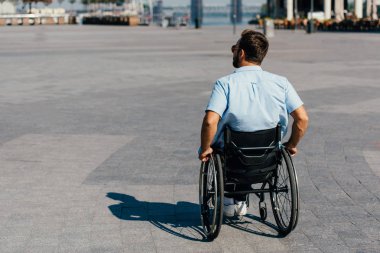 arkadan görünüşü adam tekerlekli sandalye sokakta kullanarak güneş gözlüğü