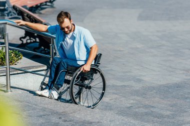 güneş gözlüğü olmadan rampa merdivenlerde tekerlekli sandalye kullanma yakışıklı adam