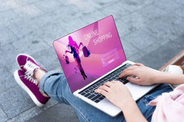 sokak online alışveriş aracı ile dizüstü bilgisayar kullanan kadın kırpılmış görüntü
