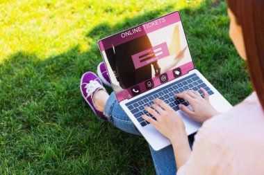 online bilet cihaz Park ile dizüstü bilgisayar kullanan kadın kırpılmış görüntü