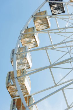 low angle view of cabins of observation wheel against blue sky in amusement park clipart