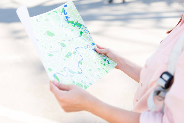 cropped image of tourist holding city map on street