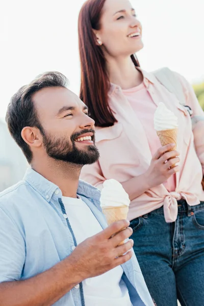 微笑英俊的男朋友在轮椅和女友与冰淇淋看着远离街道 — 免费的图库照片