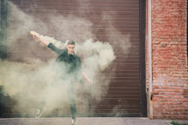 yakışıklı erkek Çağdaş dansçı sarı duman kentsel şehir sokak üzerinde 