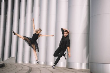 güzel genç çift siyah giysili sütunları dans dansçılar   