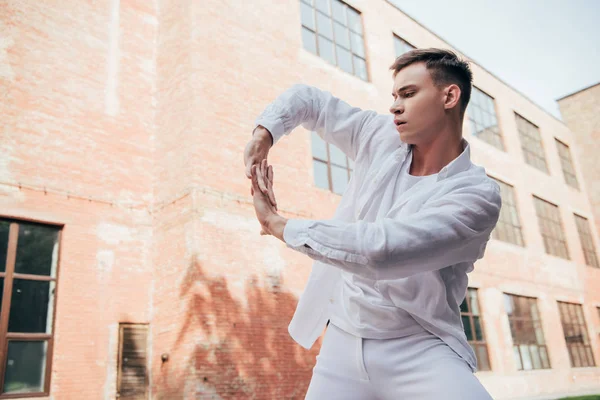 Низкий Угол Обзора Молодого Человека Белой Одежде Танцующего Городской Улице — стоковое фото