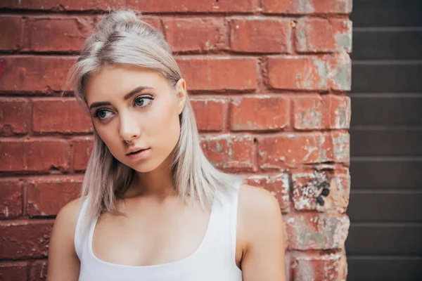 Portrait Beautiful Blonde Girl Standing Brick Wall Looking Away — Free Stock Photo