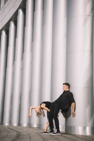 Молодая Пара Черной Одежде Танцует Возле Колонн — Бесплатное стоковое фото