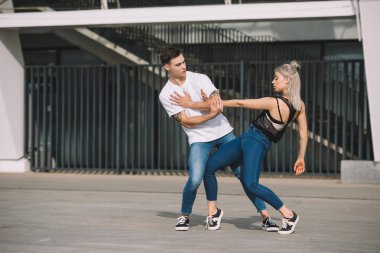 young couple of contemporary dancers practicing on urban city street   clipart