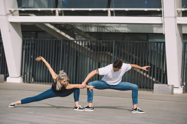 young contemporary dancers performing street dance in city