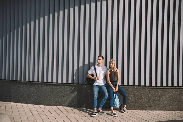 美丽的年轻夫妇与背包站在一起在街道上 — 图库照片