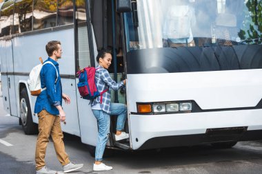 sırt çantaları içine yürüyüş ile turistler çok ırklı çift Street otobüs seyahat