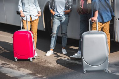 turist Seyahat Otobüs Street yakınında duran tekerlekli çanta ile kırpılmış görüntü