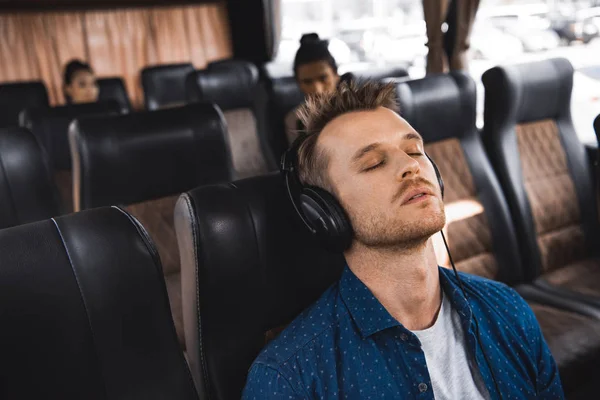 音楽を聴くと バスで旅行中に眠っているヘッドフォンで大人の男 — ストック写真