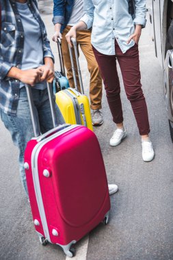 turist Seyahat Otobüs kentsel Street yakınında duran tekerlekli çanta ile kırpılmış görüntü 