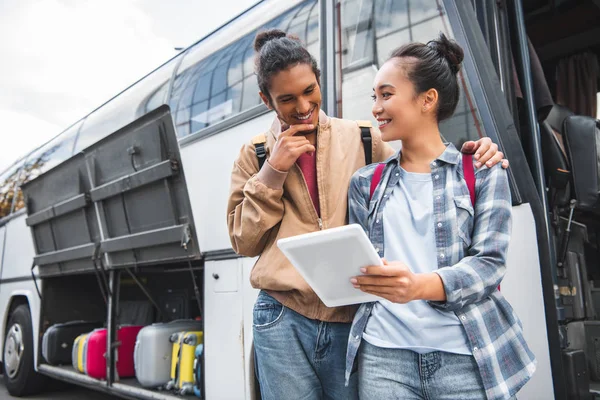 Młoda Para Międzyrasowy Turystów Stojąc Cyfrowego Tabletu Pobliżu Podróży Autobusem — Zdjęcie stockowe