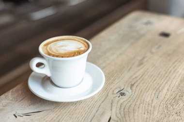 close-up shot of cup of delicious cappuccino on rustic wooden table clipart