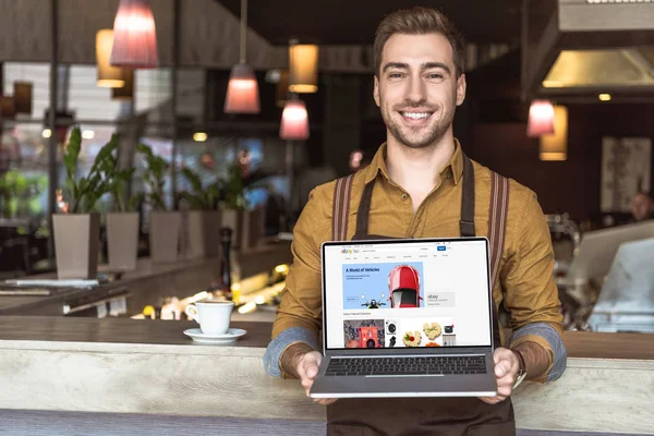 Smiling Young Waiter Holding Laptop Ebay Website Screen Cafe — Stock Photo, Image