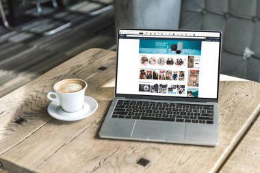 fincan kahve ve amazon Web sitesinde kafede rustik ahşap masa üstünde perde ile dizüstü bilgisayar