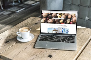 fincan kahve ve shutterstock Web sitesinde kafede ahşap masa üstünde perde ile dizüstü bilgisayar