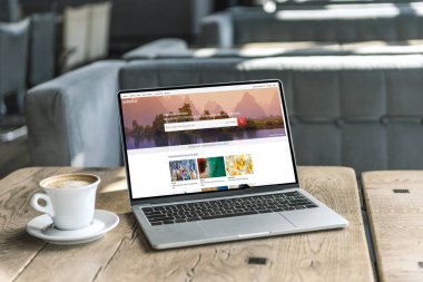 fincan kahve ve shutterstock Web sitesinde kafede rustik ahşap masa üstünde perde ile dizüstü bilgisayar
