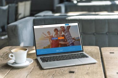 fincan kahve ve laptop ile couchsurfing Web sitesinde kafede rustik ahşap masa üstünde perde