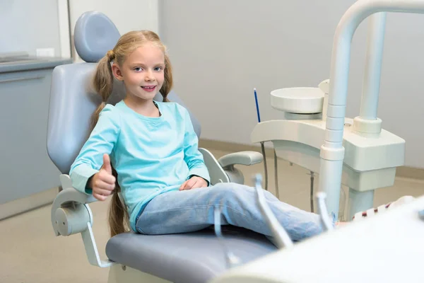 Sorrindo Criança Sentada Cadeira Dentária Consultório Odontológico Mostrando Polegar Para — Fotografia de Stock