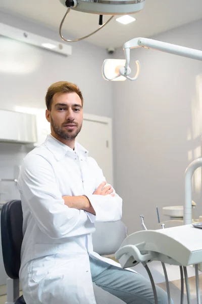 Guapo Joven Dentista Con Brazos Cruzados Mirando Cámara Oficina —  Fotos de Stock