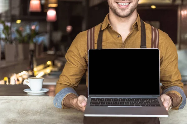 Recortado Disparo Sonriente Joven Camarero Sosteniendo Portátil Con Pantalla Blanco — Foto de Stock