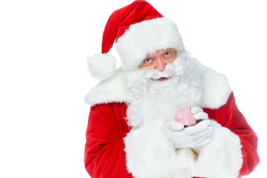 Noel küçük kumbara tutarak ve üzerinde beyaz izole kamera bakıyor
