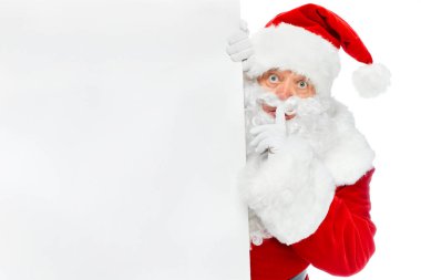 Noel Baba ile boş afişini beyaz izole sessizlik sembolünü gösterirken