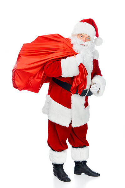santa claus in red costume carrying christmas bag isolated on white