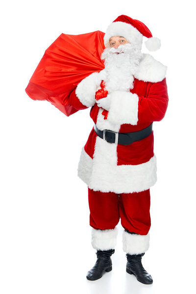 bearded santa claus carrying red christmas bag isolated on white