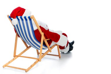 Noel Baba rahatlatıcı beyaz plaj sandalye üzerinde dikiz