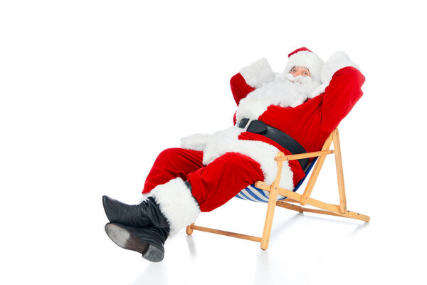 happy santa claus relaxing on beach chair on white
