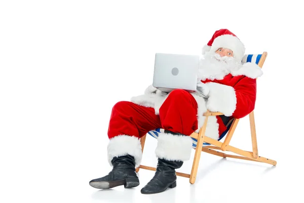 Noel Baba Beyaz Izole Plaj Sandalyesi Üzerinde Otururken Dizüstü Bilgisayar — Ücretsiz Stok Fotoğraf