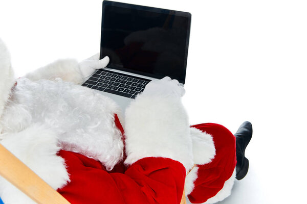 cropped view of santa claus using laptop with blank screen isolated on white