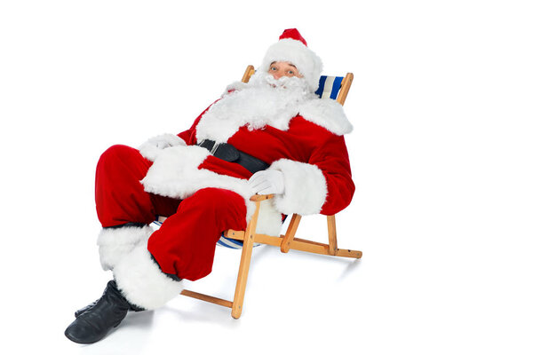 happy santa claus resting on beach chair on white
