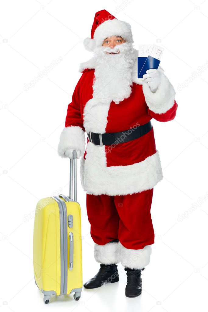 santa claus with travel bag holding two passports and air tickets for christmas trip isolated on white