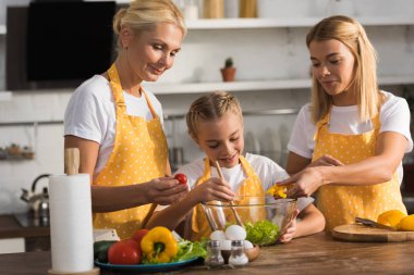 Annem ve büyükannem sebze salatası birlikte mutfakta yemek ile şirin mutlu çocuk 