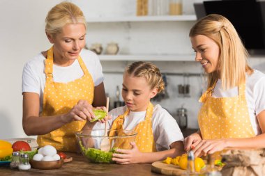 Annem ve büyükannem yemek mutfakta sebze salata ile harika çocuk