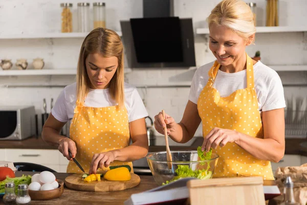 Adult Mor Och Dotter Förkläden Matlagning Grönsakssallad Tillsammans Köket — Gratis stockfoto
