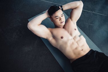 Genç Asyalı sporcu ile çıplak göğüs abs egzersiz fitness mat vasıl jimnastik salonu